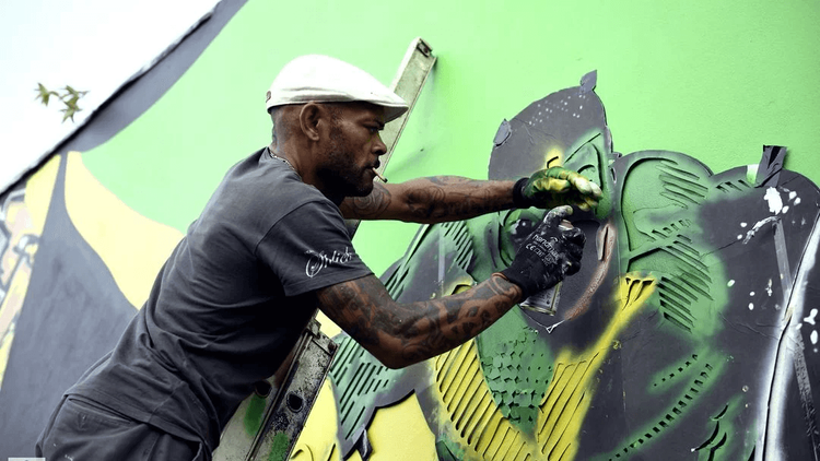 Man spray painting a mural in Brazil
